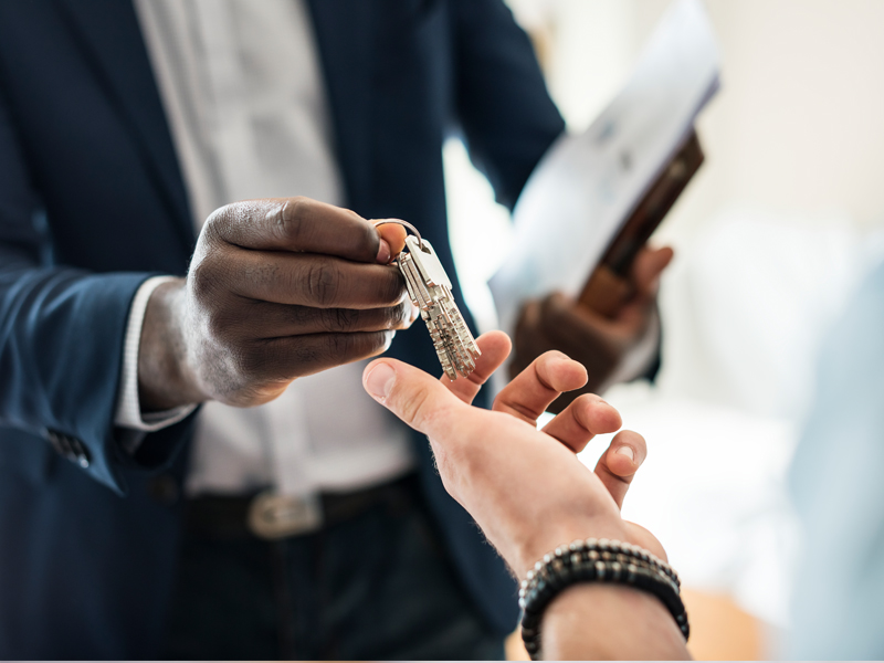 Property manager professional, handing the house key to a client