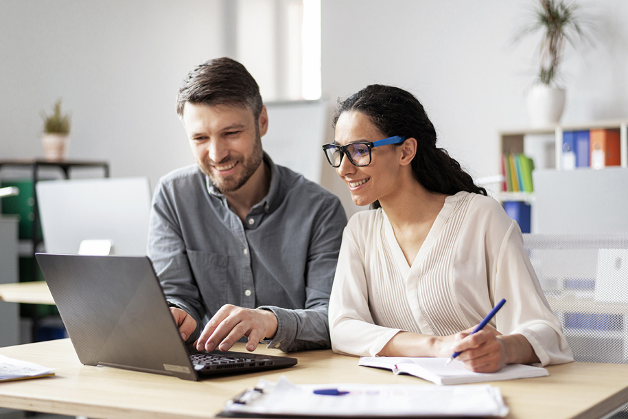 A couple smiling with a laptop