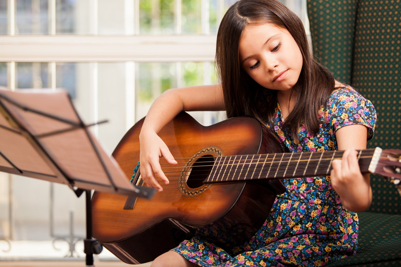 Young lady learning to play guitar