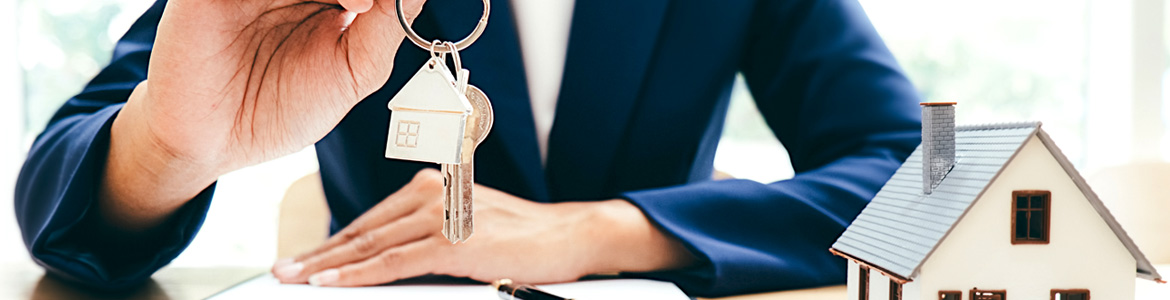Real Estate agent on a desk with property keys at hand