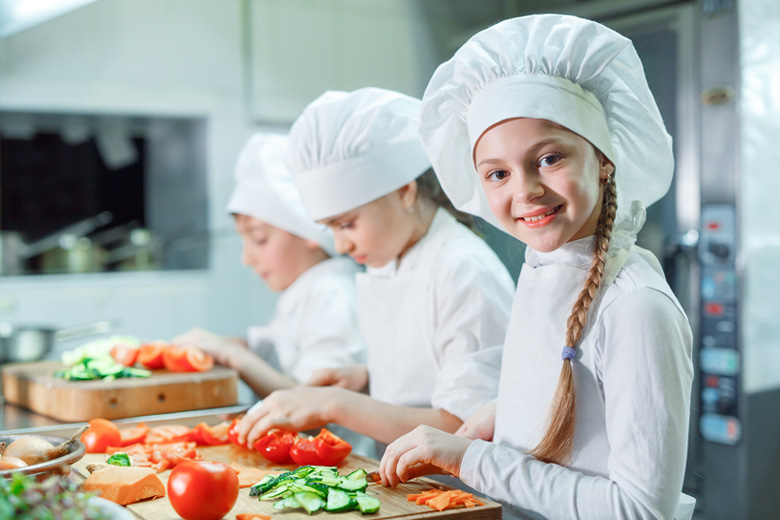 Group of young ladies cooking in a chef outfit